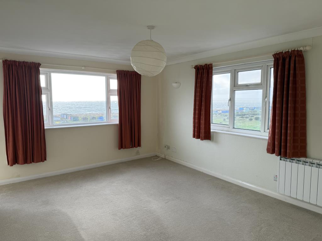 Lot: 126 - TWO-BEDROOM TOP FLOOR FLAT WITH UNINTERRUPTED SEA VIEWS - Living room with fitted carpet and painted walls